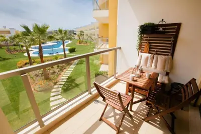 a balcony with a table and chairs and a view of a pool at Jardins da Marina Albufeira in Albufeira