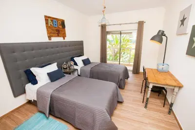 a bedroom with two beds and a table and a desk at Jardins da Marina Albufeira in Albufeira