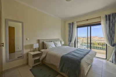 a bedroom with a bed and a large window at Vista das Ondas - Apartamento 204 in Albufeira