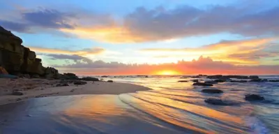 a sunset on a beach with the ocean at Vista das Ondas - Apartamento 204 in Albufeira