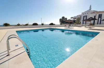 a large swimming pool with blue water at Apartamento Varandas do Mar in Albufeira