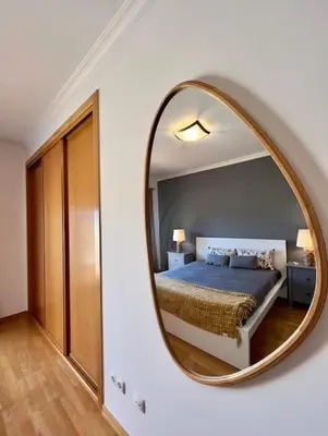 a bedroom with a bed and a round mirror at Vivenda em Vilamoura Marina Ténis Academy in Vilamoura
