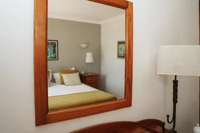 a bedroom with a mirror on the wall at Vila Limão in Boliqueime
