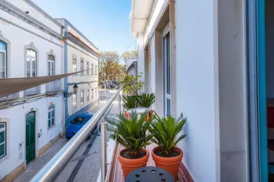 a balcony with potted plants on a building at Happen!ng 2 in Faro