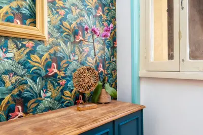 a room with a wall with a floral wallpaper at Happen!ng 2 in Faro