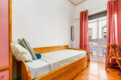 a small bedroom with a bed and a window at Happen!ng 2 in Faro