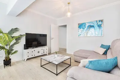 a living room with a couch and a tv at Ria Mar Deluxe - City Center @Homesbyfc in Faro
