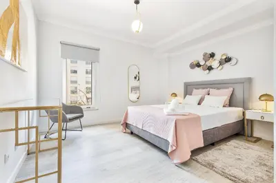 a white bedroom with a bed and a desk at Ria Mar Deluxe - City Center @Homesbyfc in Faro