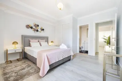 a bedroom with a large bed with a pink blanket at Ria Mar Deluxe - City Center @Homesbyfc in Faro