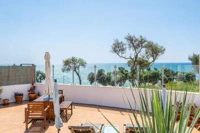 a balcony with chairs and a view of the ocean at Stunning terrace with ocean view in Albufeira