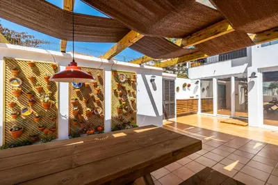 a patio with a wooden table and a wall with a painting at Stunning terrace with ocean view in Albufeira