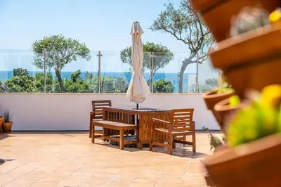 a table and chairs with an umbrella on a patio at Stunning terrace with ocean view in Albufeira
