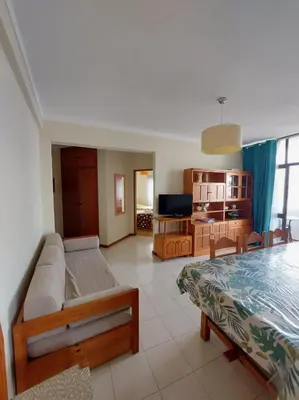 a living room with a bed and a television at Coluna Mar in Quarteira