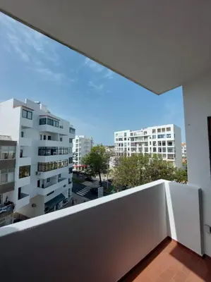 a balcony with a view of a city with buildings at Coluna Mar in Quarteira