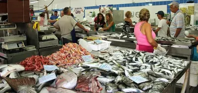 a group of people working in a fish market at Coluna Mar in Quarteira