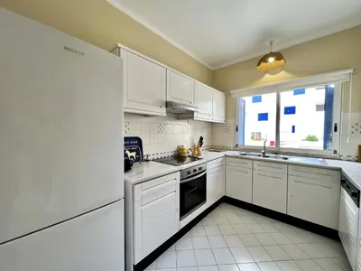 a white kitchen with white appliances and a window at Albufeira Sunset With Pool by Homing in Albufeira
