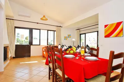 a dining room with a red table and chairs at Villa Isis by Algarve Vacation in Albufeira
