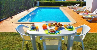 a table with food and drinks on it next to a pool at Villa Isis by Algarve Vacation in Albufeira