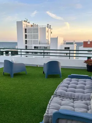 a balcony with two chairs and a couch on the grass at Ocean Blue in Quarteira
