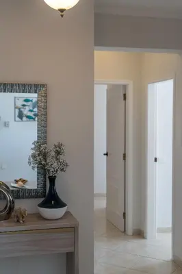 a hallway with a vase on a table and a mirror at Ocean Blue in Quarteira