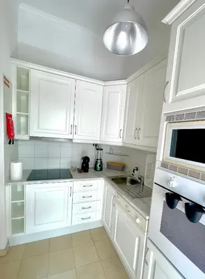 a white kitchen with white cabinets and a sink at Detailed Villa - In Vilamoura's Heart in Vilamoura