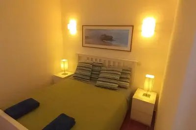 a small bedroom with a bed with two lights on it at Bela Vista Algarve in Albufeira