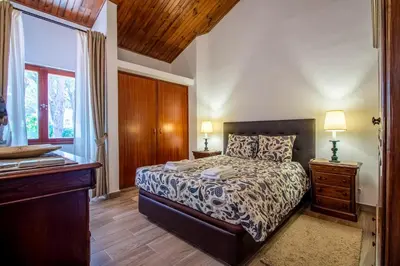 a bedroom with a bed and a dresser and a window at Casa da Aldeia in Albufeira