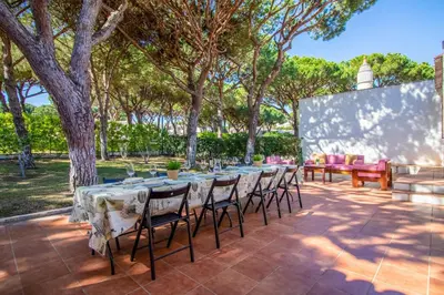 a table and chairs on a patio with trees at Casa da Aldeia in Albufeira