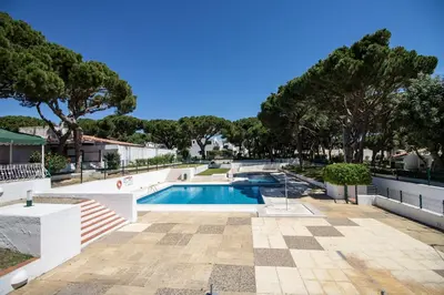 a swimming pool with trees in the background at Casa da Aldeia in Albufeira