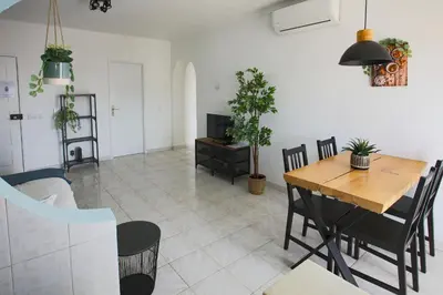 a living room with a wooden table and chairs at Go4Portugal - Dinis - Luxe Condo with Pool, Airco, Seaview with two Balcony in Albufeira