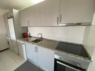 a kitchen with white cabinets and a sink at House Т1 Bella Vista in Albufeira