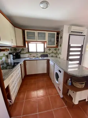a kitchen with a sink and a washing machine at Beach Villa Alfamar Praia da Falésia in Albufeira