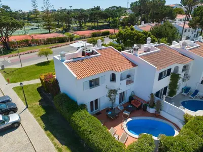 a patio with a table and chairs and an umbrella at Vila Senna in Vale do Lobo