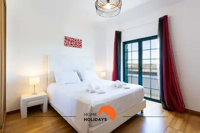 a bedroom with a bed and a large window at #146 Summer House A6 by Home Holidays in Ferreiras