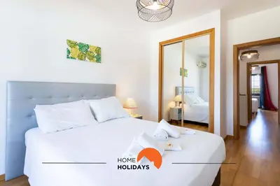 a bedroom with a large white bed and a mirror at #146 Summer House A6 by Home Holidays in Ferreiras