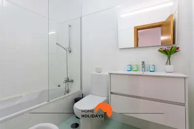 a bathroom with a toilet and a sink and a mirror at #146 Summer House A6 by Home Holidays in Ferreiras