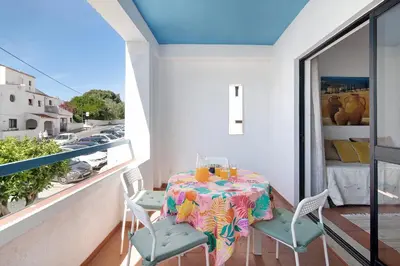 a balcony with a table and chairs and a window at Mar azul 3 in Albufeira