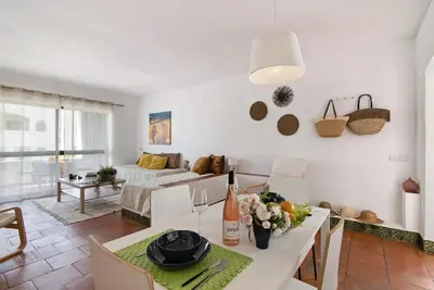 a kitchen and living room with a table and chairs at Mar azul 3 in Albufeira