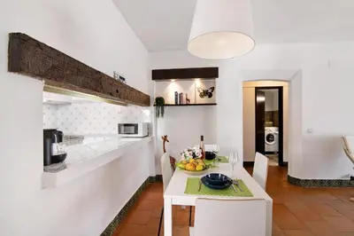 a kitchen with a white table with a bowl of fruit on it at Mar azul 3 in Albufeira