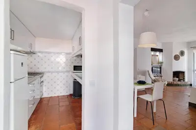 a kitchen and dining room with a table and chairs at Mar azul 3 in Albufeira