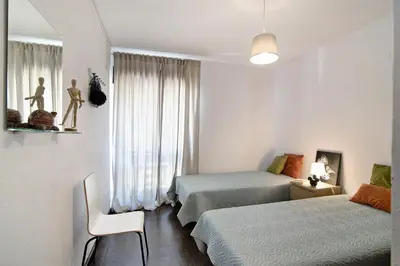 a small bedroom with two beds and a window at Mar azul 3 in Albufeira