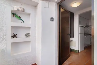 a hallway with white walls and shelves on the wall at Mar azul 3 in Albufeira