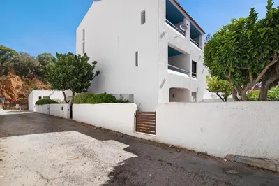 a white house with a white fence and trees at Mar azul 3 in Albufeira