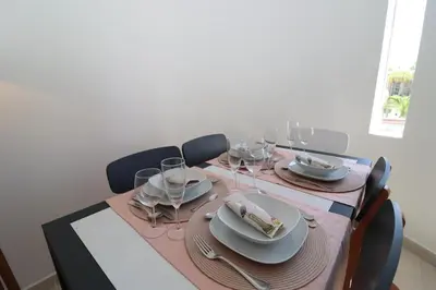 a dining room table with plates and wine glasses at São Rafael Beach Apartment 92A, Albufeira - Algarve in Albufeira