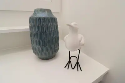 a bird standing next to a vase on a table at São Rafael Beach Apartment 92A, Albufeira - Algarve in Albufeira