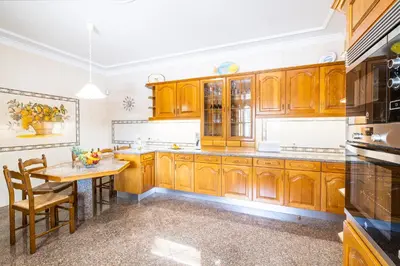 a kitchen with wooden cabinets and a wooden table at Villa Rose Bay by Algarve Vacation in Albufeira