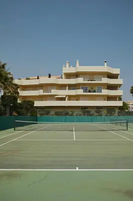 a tennis court in front of a large building at Casa Terra with Pool & Free WiFi in Albufeira