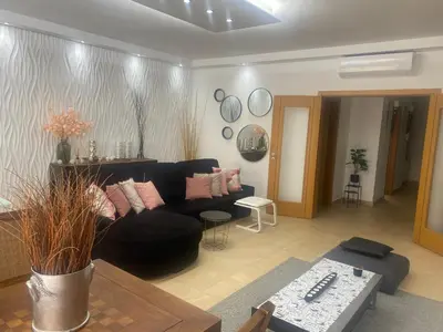 a living room with a black couch and a table at Villa Jardins 3 by Sunny Deluxe in Albufeira