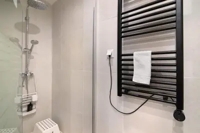a bathroom with a shower and a towel rack at Casa na Travessa 2 in Faro