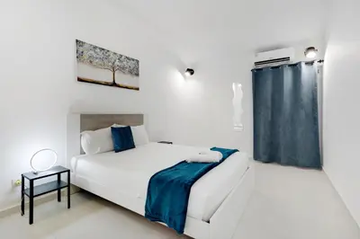 a white bedroom with a bed and a window at Poolside Villa Sereno in Albufeira